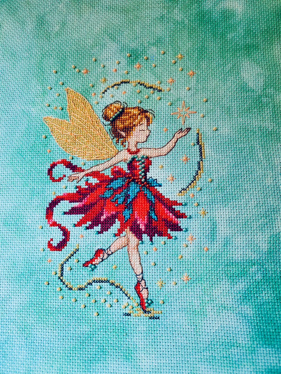 Finished Lyssia Christmas Pixieling cross stitch in red and teal with golden wings